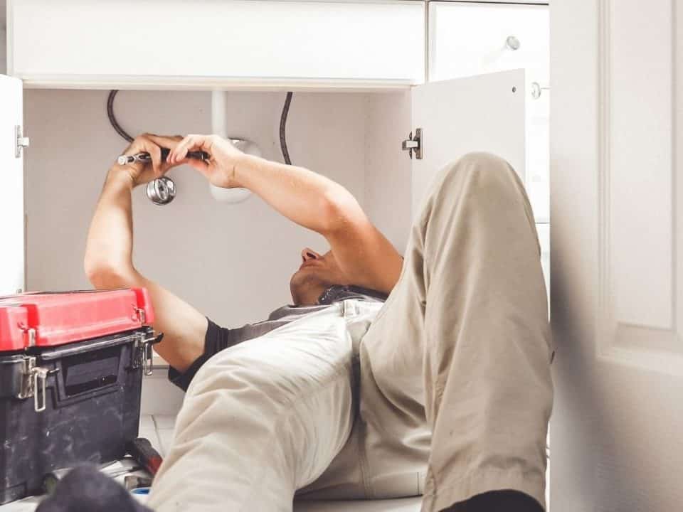 Image of man fixing plumbing issues